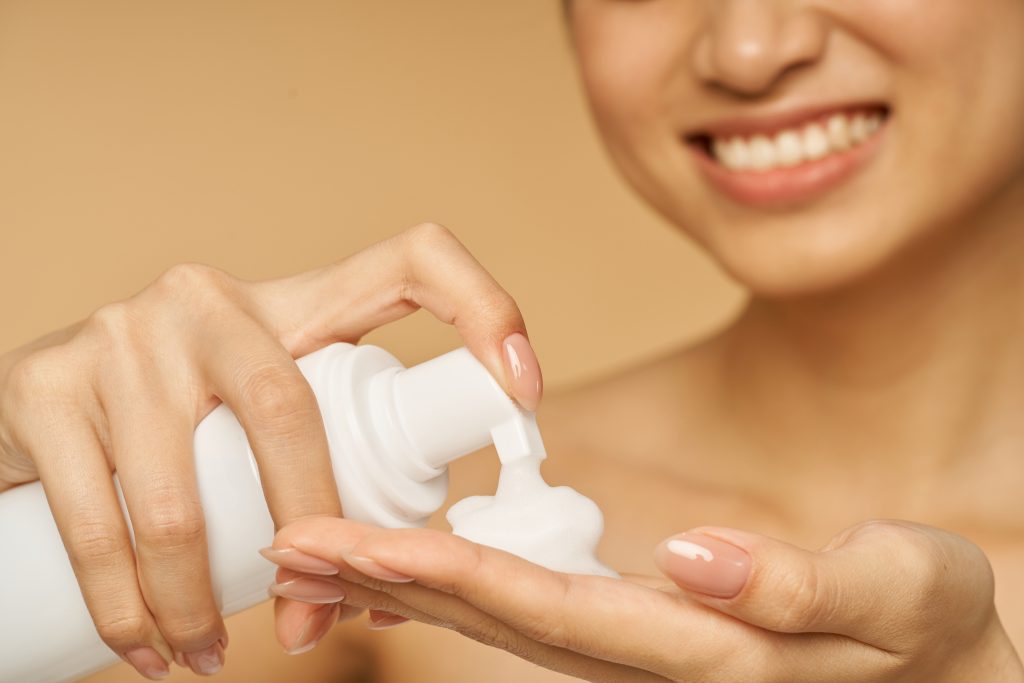 a lady holding a bottle of gentle foam facial cleanser